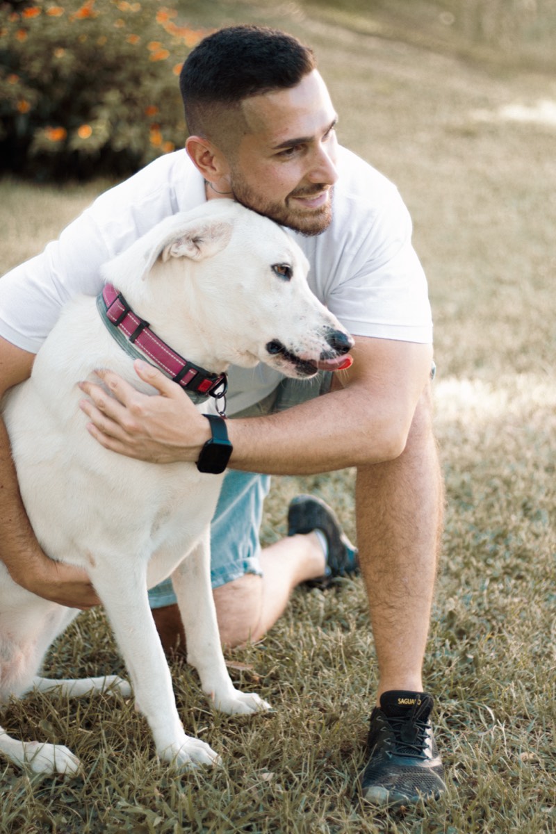 Davide Cabras accarezza un cane bianco