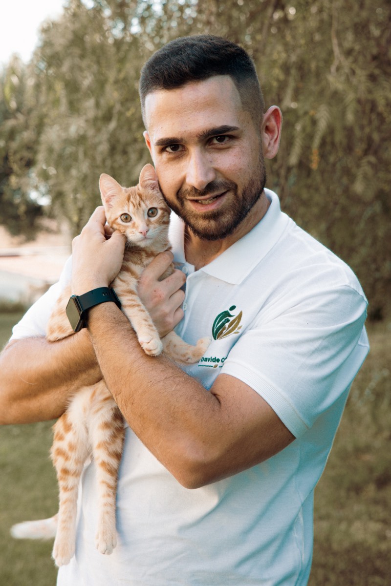 Davide Cabras con un gattino rosso in braccio